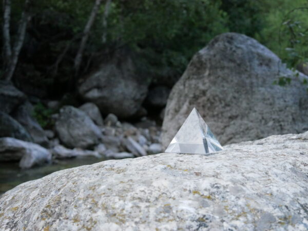 Oerlicht piramide op grote steen aan beek